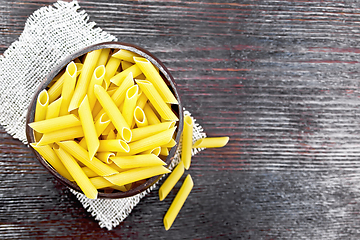 Image showing Penne in bowl of coconut on board top