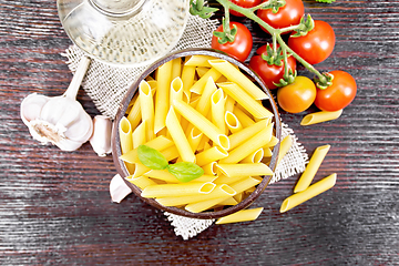 Image showing Penne in bowl of coconut with vegetables on dark board top