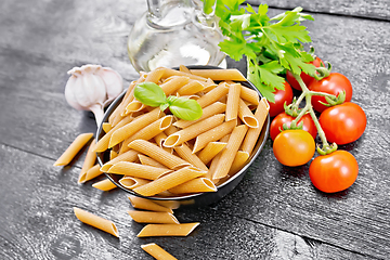 Image showing Penne whole grain in bowl with vegetables on black board