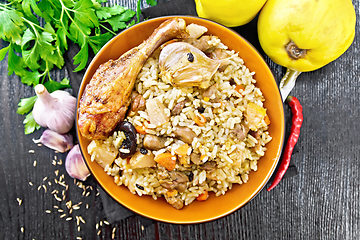 Image showing Pilaf with duck and quince in plate on dark board top