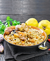 Image showing Pilaf with duck and quince in plate on towel