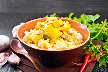 Image showing Porridge millet with spicy pumpkin in clay bowl on black board