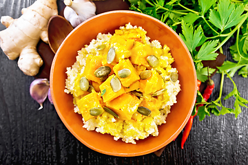 Image showing Porridge millet with spicy pumpkin in clay bowl on board top