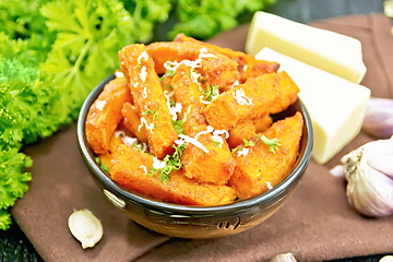 Image showing Pumpkin fried with spices in bowl on wooden board