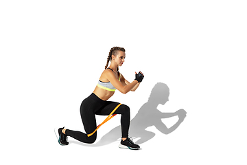 Image showing Beautiful young female athlete practicing on white studio background with shadows