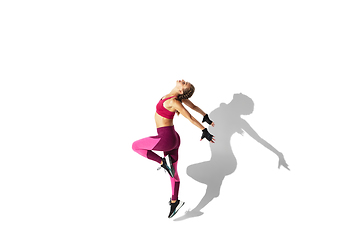 Image showing Beautiful young female athlete practicing on white studio background with shadows