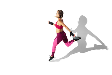 Image showing Beautiful young female athlete practicing on white studio background with shadows