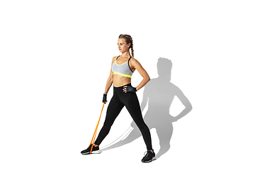 Image showing Beautiful young female athlete practicing on white studio background with shadows