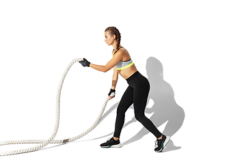 Image showing Beautiful young female athlete practicing on white studio background with shadows