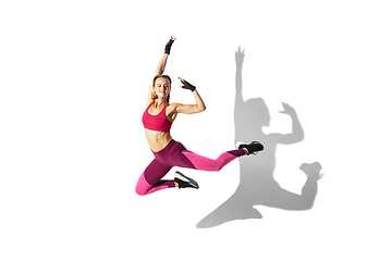 Image showing Beautiful young female athlete practicing on white studio background with shadows