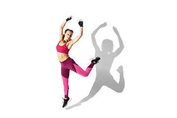 Image showing Beautiful young female athlete practicing on white studio background with shadows