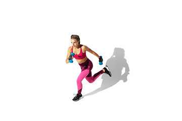 Image showing Beautiful young female athlete practicing on white studio background with shadows
