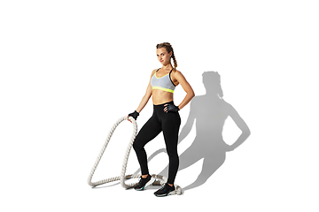 Image showing Beautiful young female athlete practicing on white studio background with shadows