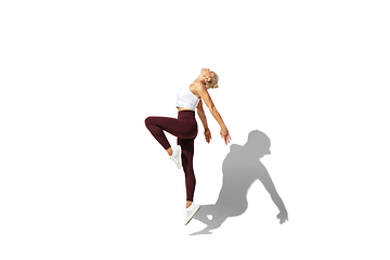 Image showing Beautiful young female athlete practicing on white studio background with shadow