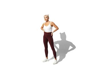 Image showing Beautiful young female athlete practicing on white studio background with shadow