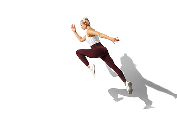 Image showing Beautiful young female athlete practicing on white studio background with shadow