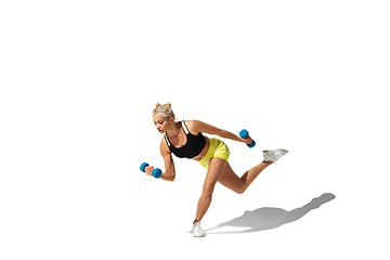 Image showing Beautiful young female athlete practicing on white studio background with shadow