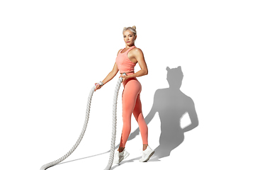 Image showing Beautiful young female athlete practicing on white studio background with shadow