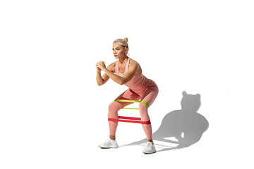 Image showing Beautiful young female athlete practicing on white studio background with shadow