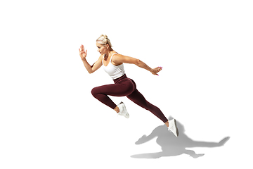 Image showing Beautiful young female athlete practicing on white studio background with shadow