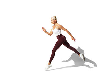 Image showing Beautiful young female athlete practicing on white studio background with shadow