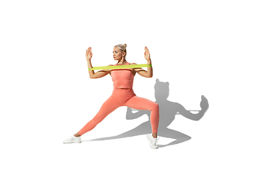 Image showing Beautiful young female athlete practicing on white studio background with shadow