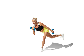 Image showing Beautiful young female athlete practicing on white studio background with shadow