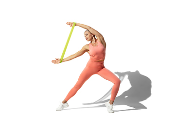 Image showing Beautiful young female athlete practicing on white studio background with shadow