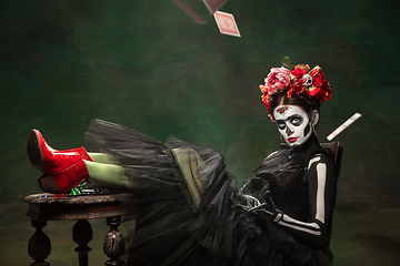 Image showing Young girl in the image of Santa Muerte, Saint death or Sugar skull with bright make-up. Portrait isolated on studio background.