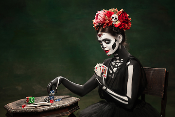 Image showing Young girl in the image of Santa Muerte, Saint death or Sugar skull with bright make-up. Portrait isolated on studio background.