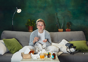 Image showing Ill young girl with fever and cold looks suffering at home