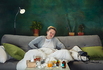 Image showing Ill young girl with fever and cold looks suffering at home