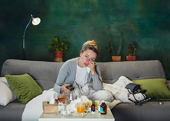 Image showing Ill young girl with fever and cold looks suffering at home