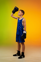 Image showing Teenage boxer against gradient neon studio background in motion of kicking, boxing