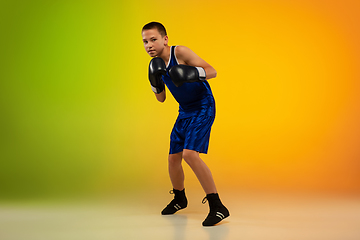 Image showing Teenage boxer against gradient neon studio background in motion of kicking, boxing