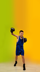 Image showing Teenage boxer against gradient neon studio background in motion of kicking, boxing