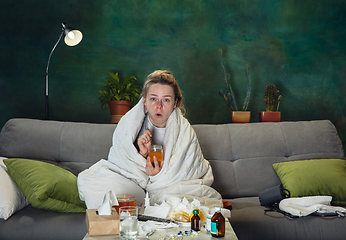 Image showing Ill young girl with fever and cold looks suffering at home