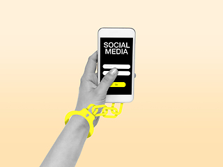 Image showing Hand using smartphone, device on top view. Addicted, wired with chain to social media on the screen