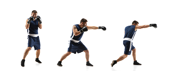 Image showing Young boxer against white studio background in motion of step-to-step kicking