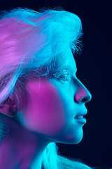 Image showing Portrait of beautiful albino girl isolated on dark studio background in neon light