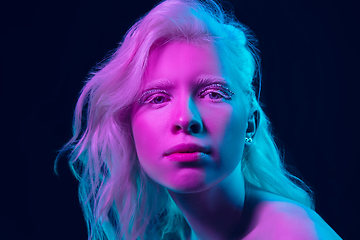 Image showing Portrait of beautiful albino girl isolated on dark studio background in neon light