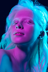 Image showing Portrait of beautiful albino girl isolated on dark studio background in neon light