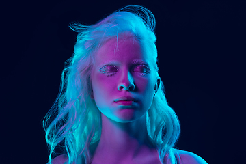 Image showing Portrait of beautiful albino girl isolated on dark studio background in neon light