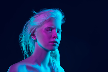 Image showing Portrait of beautiful albino girl isolated on dark studio background in neon light