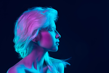 Image showing Portrait of beautiful albino girl isolated on dark studio background in neon light