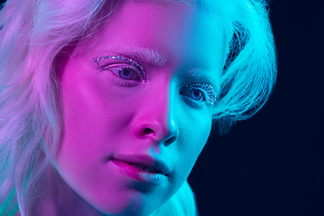 Image showing Portrait of beautiful albino girl isolated on dark studio background in neon light