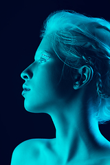 Image showing Portrait of beautiful albino girl isolated on dark studio background in neon light