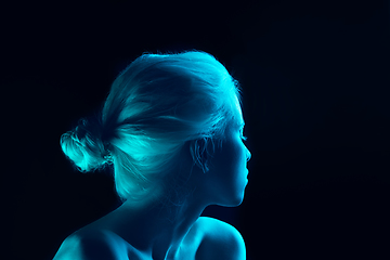 Image showing Portrait of beautiful albino girl isolated on dark studio background in neon light