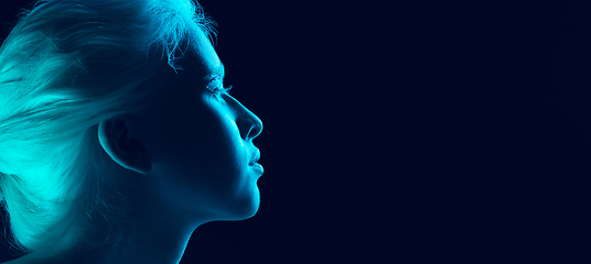 Image showing Portrait of beautiful albino girl isolated on dark studio background in neon light