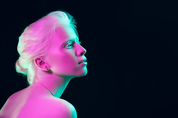 Image showing Portrait of beautiful albino girl isolated on dark studio background in neon light